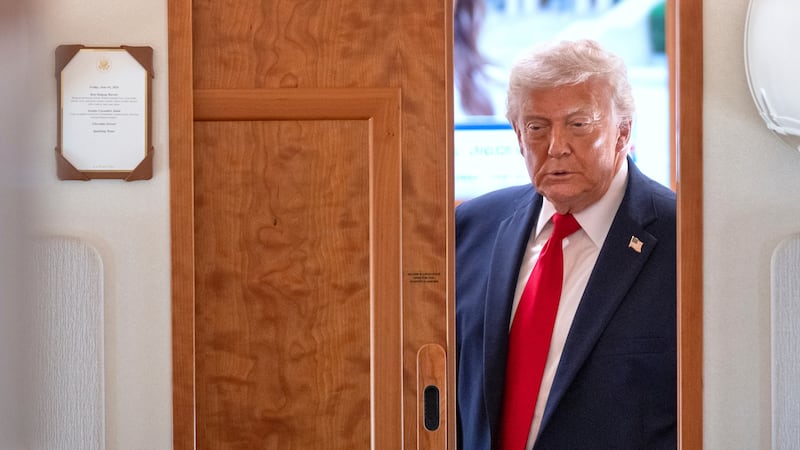 President Donald Trump arrives to speak to reporters aboard Air Force One en route from Joint...